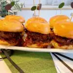 Whiskey Bacon Onion Sliders on a tray with cute football picks.