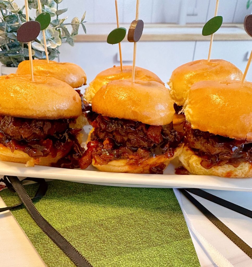 Whiskey Bacon Onion Sliders on a tray with cute football picks.