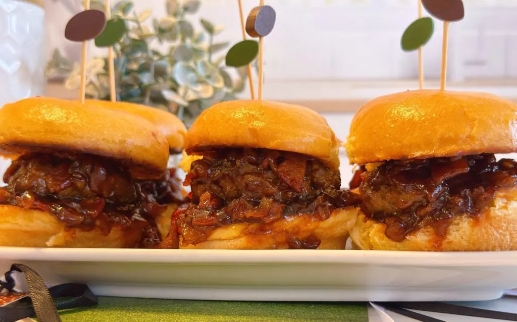 Sliders all lined up on a serving tray ready to eat.