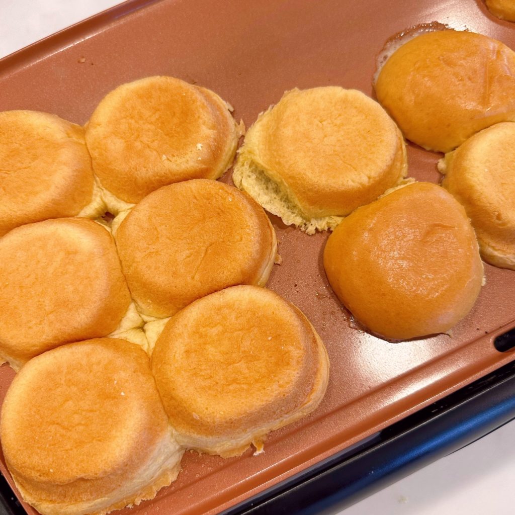 Buns toasting on a griddle.