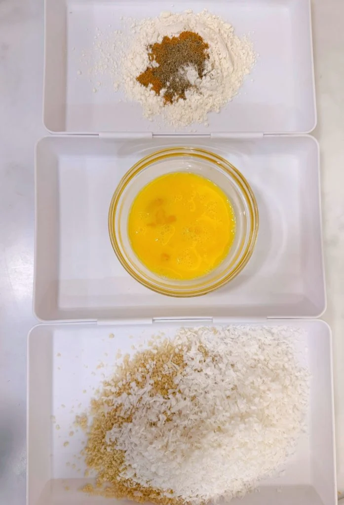 Three dredged dishes with flour, eggs, and coconut.