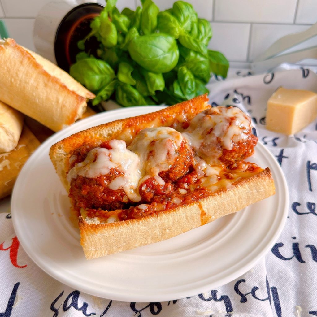 Slow Cooker Meatball Sub sandwich on a bun with sauce and melted cheese.