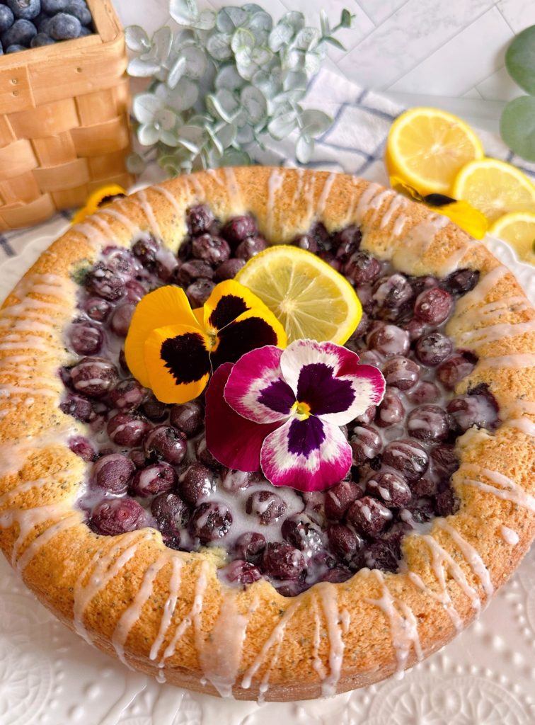 Lemon Blueberry Poppy Seed Cake with fresh pansies and lemon slices. 