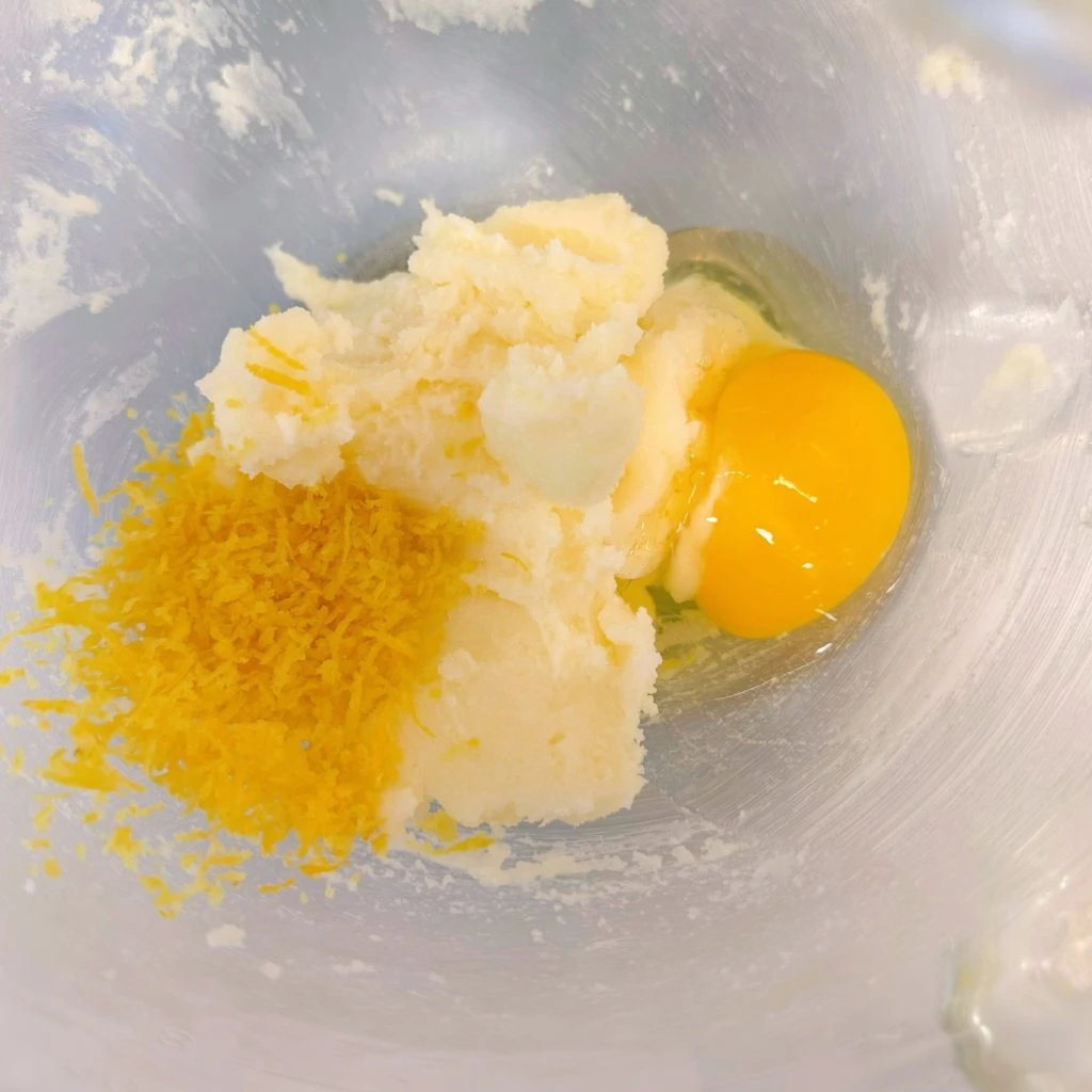 Add egg and lemon zest to the butter and sugar mixture.