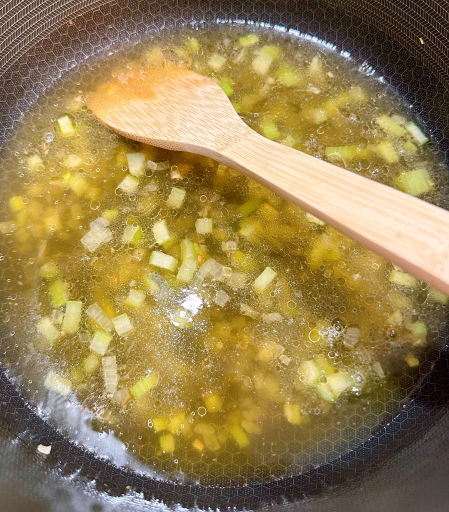 Add chicken broth and water to sautéed onions and celery.