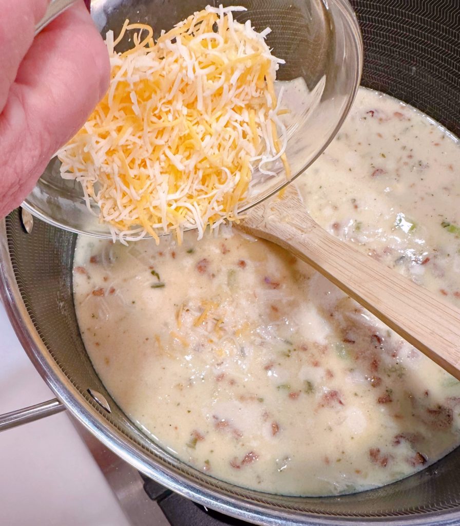 Add the shredded cheese to the soup.