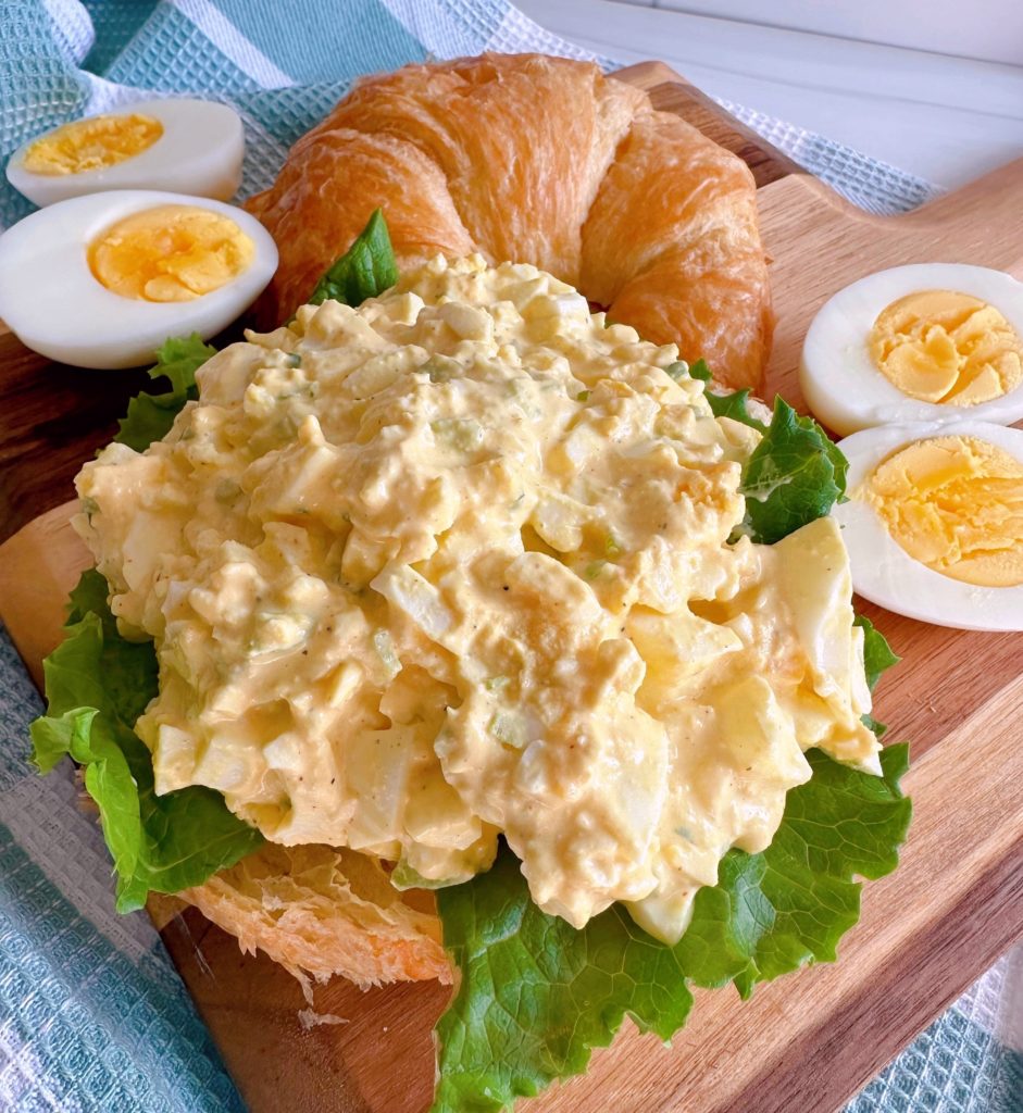 Prepared Egg Salad on lettuce with hard boiled eggs surrounding it.