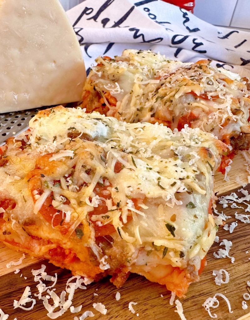 Deep Dish pizza cooked an on a wooden cutting board.